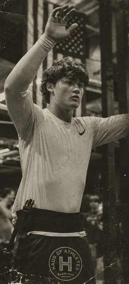 A HAUS athlete on the training floor, arm raised